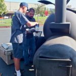 AJ preparing meat for smoking in big smoker