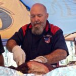 Spud's pitmaster checks the brisket for the judging