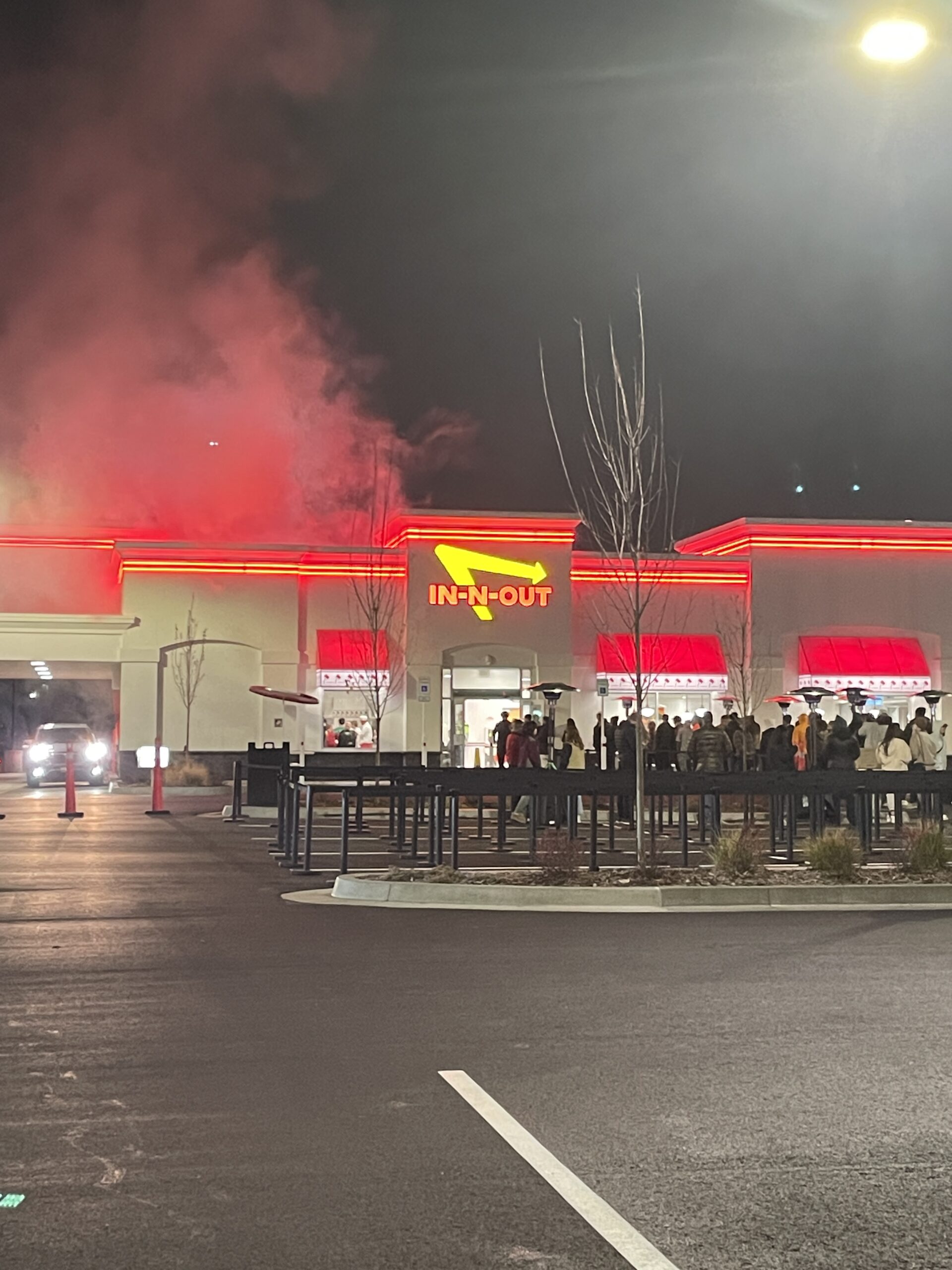 In-N-Out Burger outside view with line and smoke billowing from above as fresh Double Double burgers are cooking inside in Meridian, Idaho.