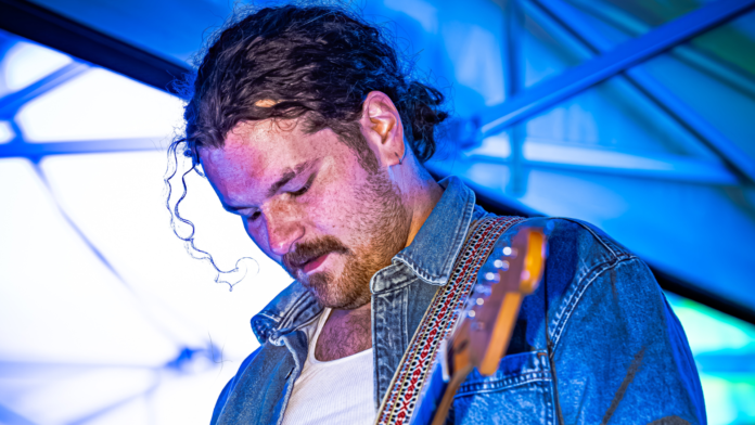 Brady Stablein of Brother Elsey engrossed in playing his guitar during a concert.