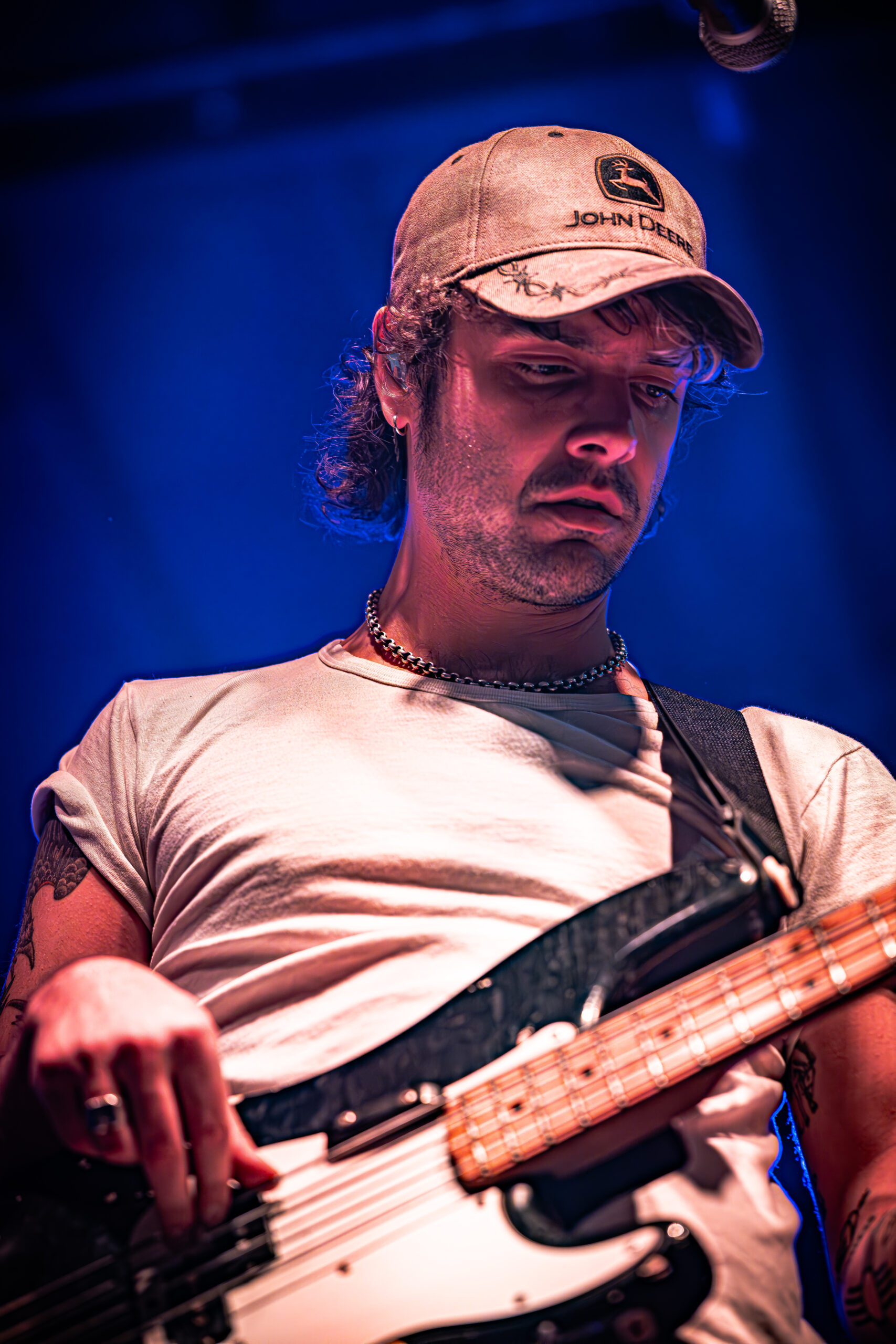 Focused guitarist performing under blue stage lights.