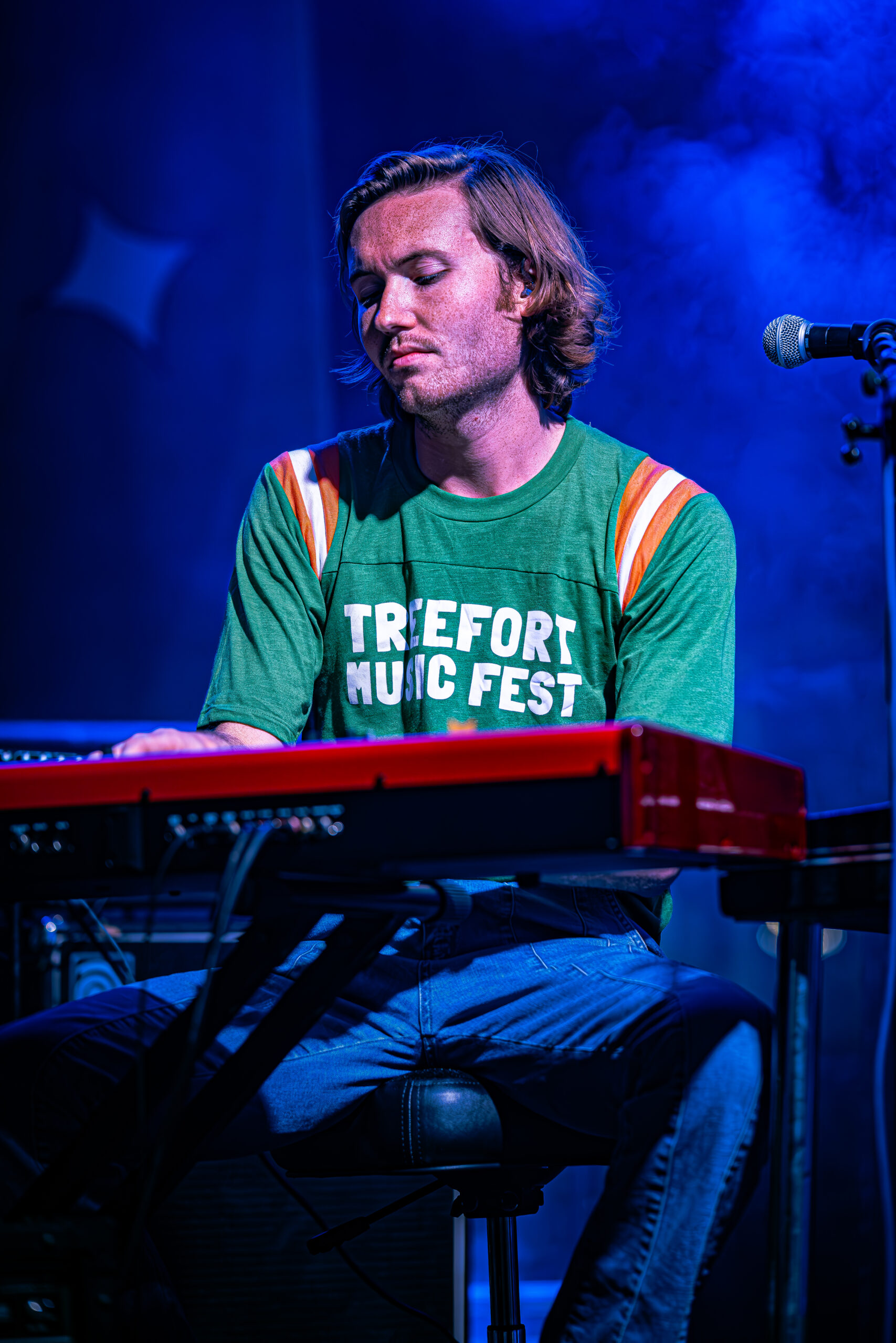 Keyboardist engrossed in playing at a music festival.