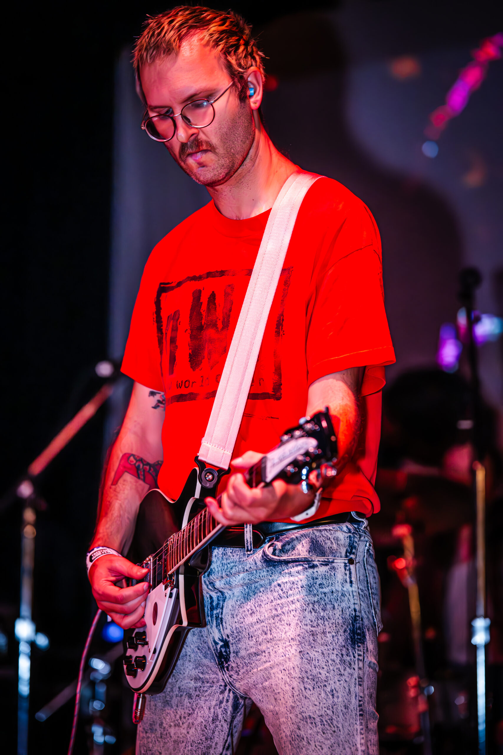 Musician playing guitar on stage.