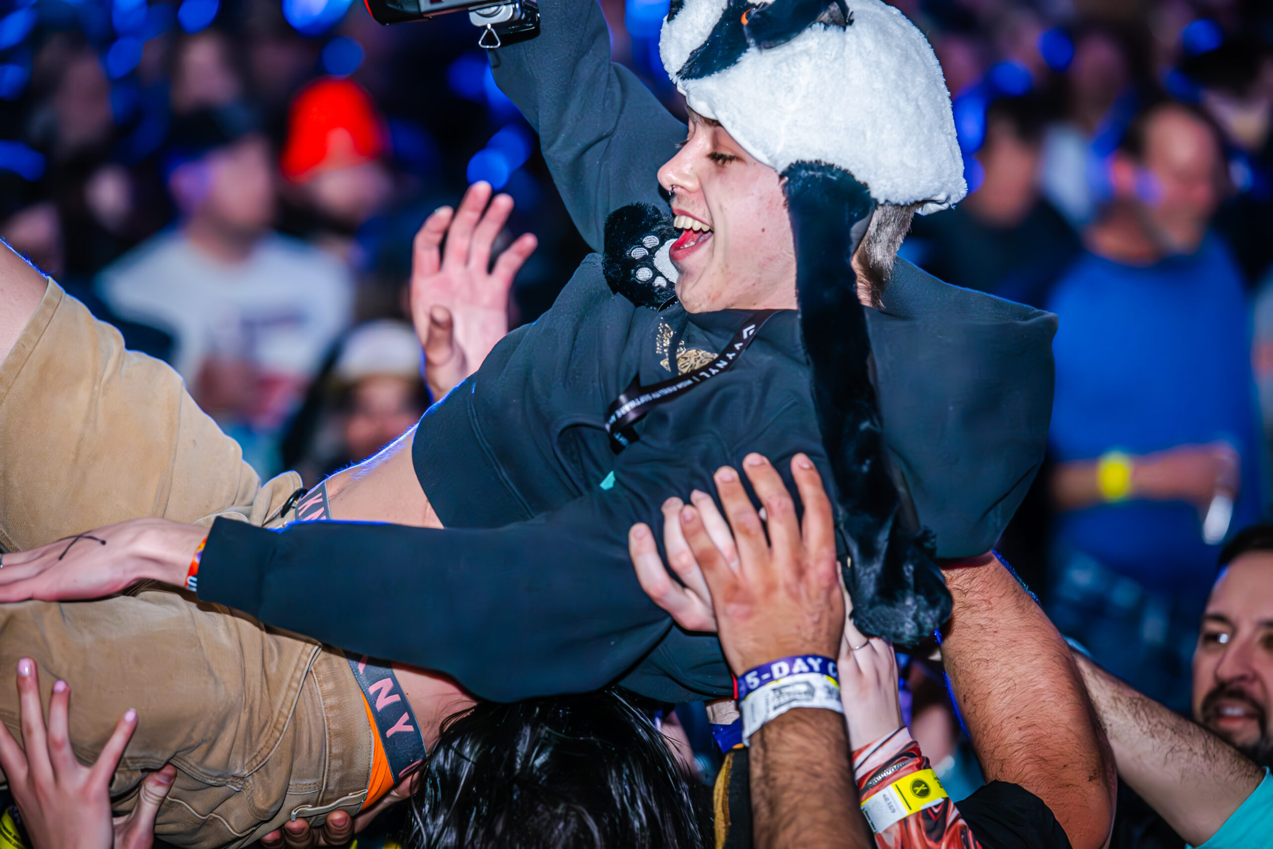 Audience member in a panda hat crowd surfing.