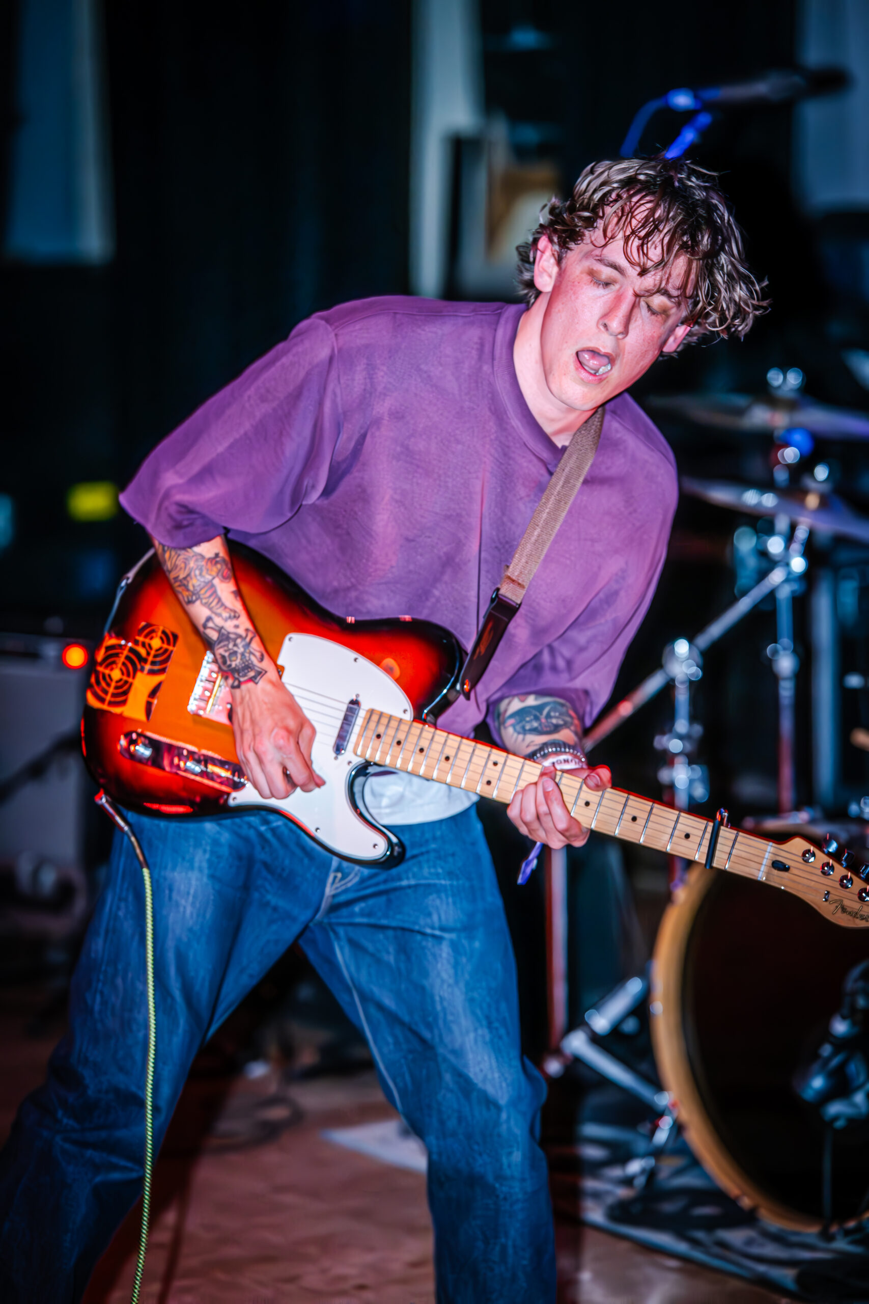 Guitarist making an emotional expression while playing.