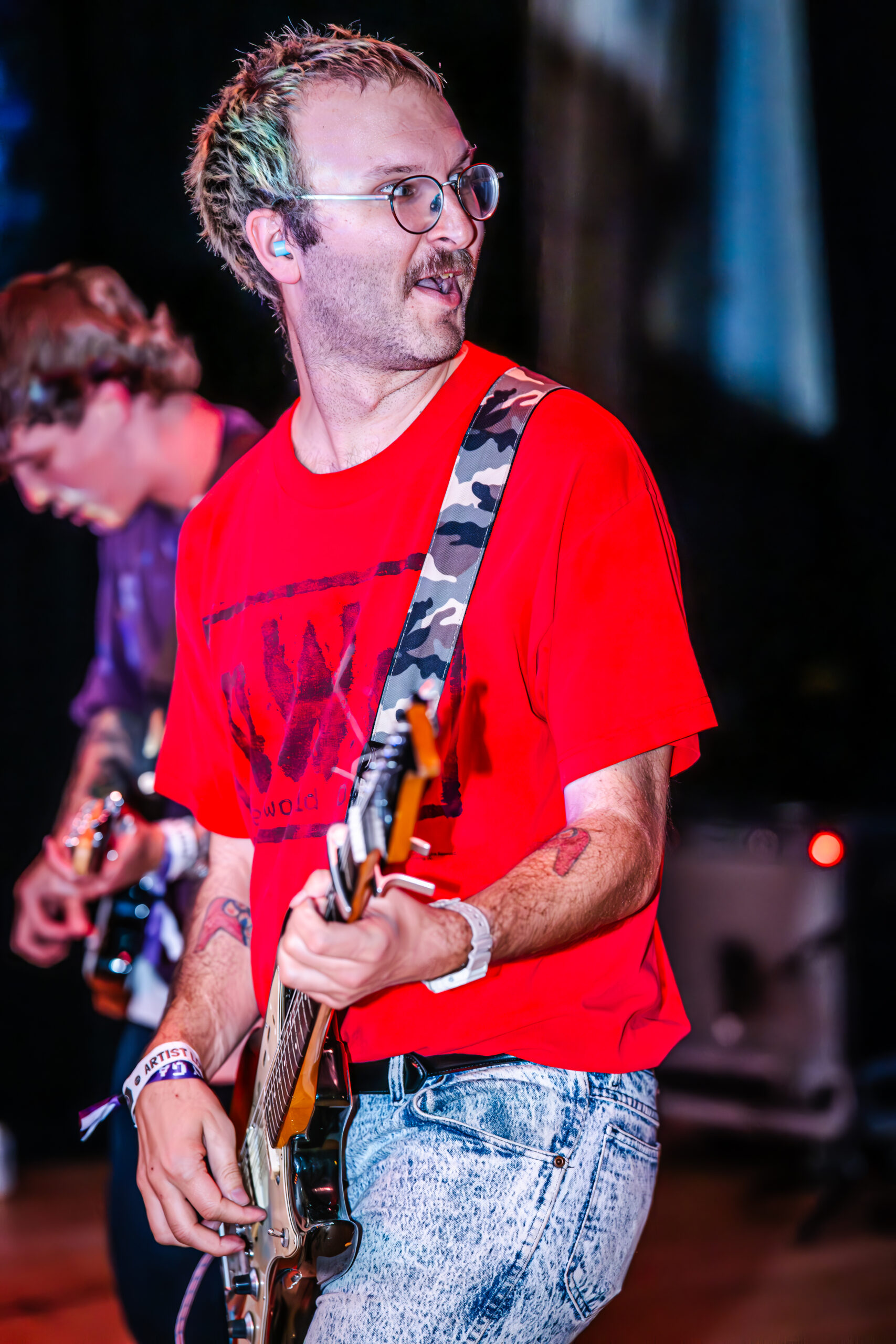 Guitarist making an emotional expression while playing.