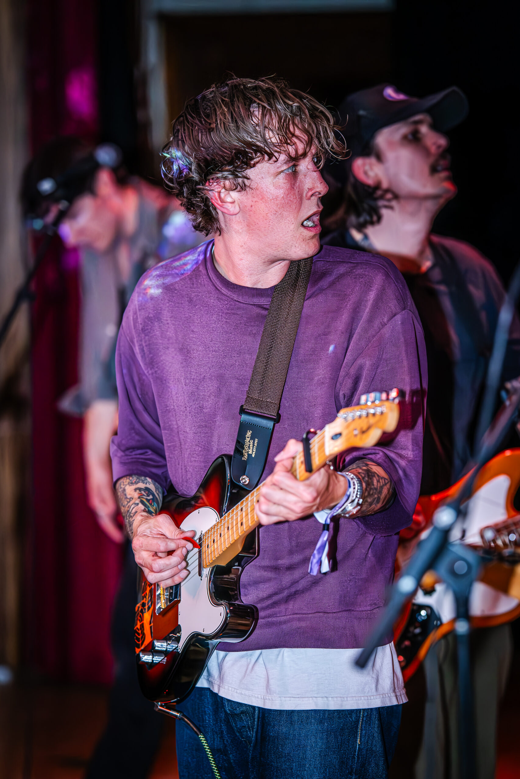 Guitarist making an emotional expression while playing.