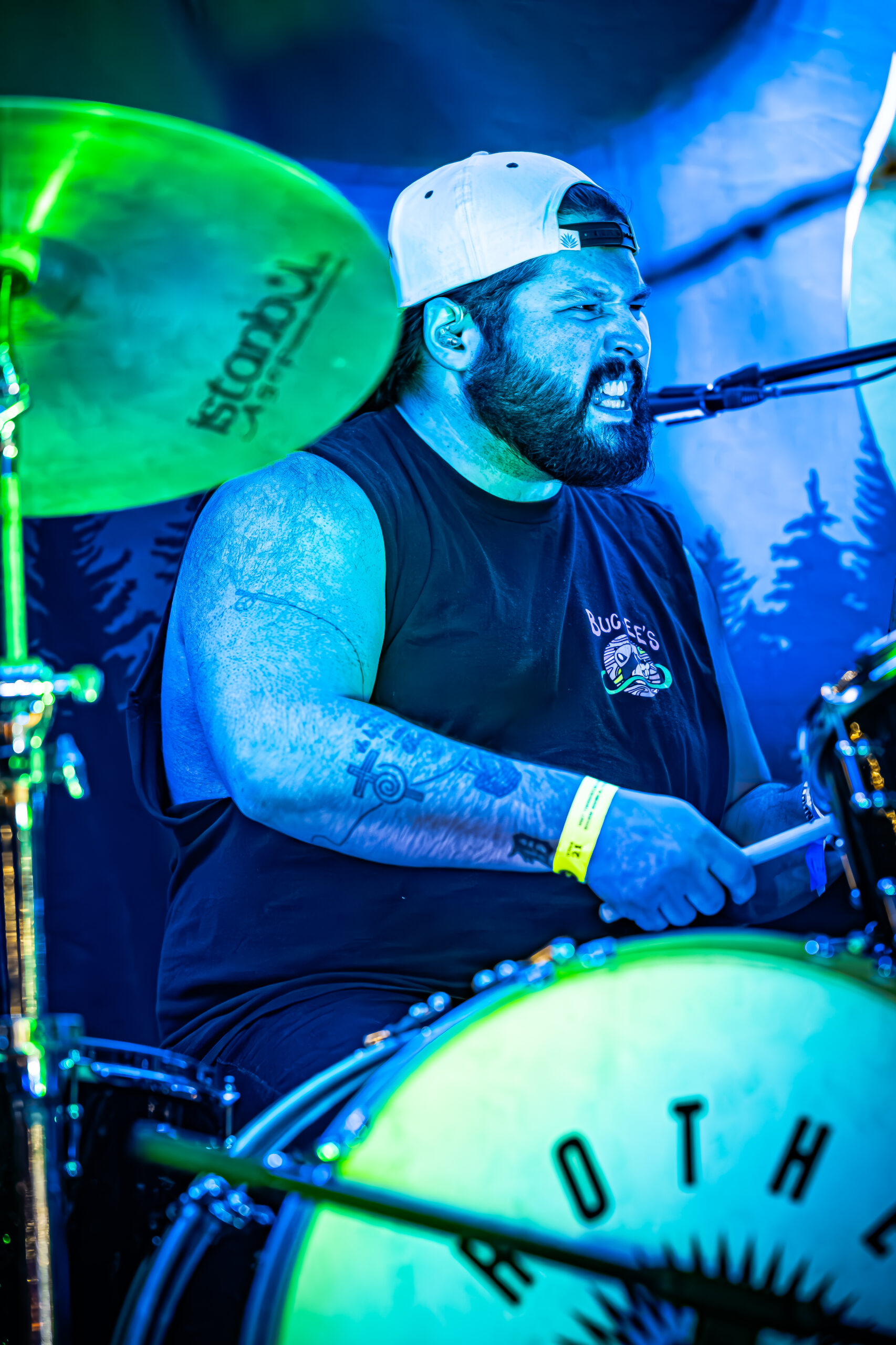 Dalton Thomas of Brother Elsey singing while playing the drums in a vibrant live show.