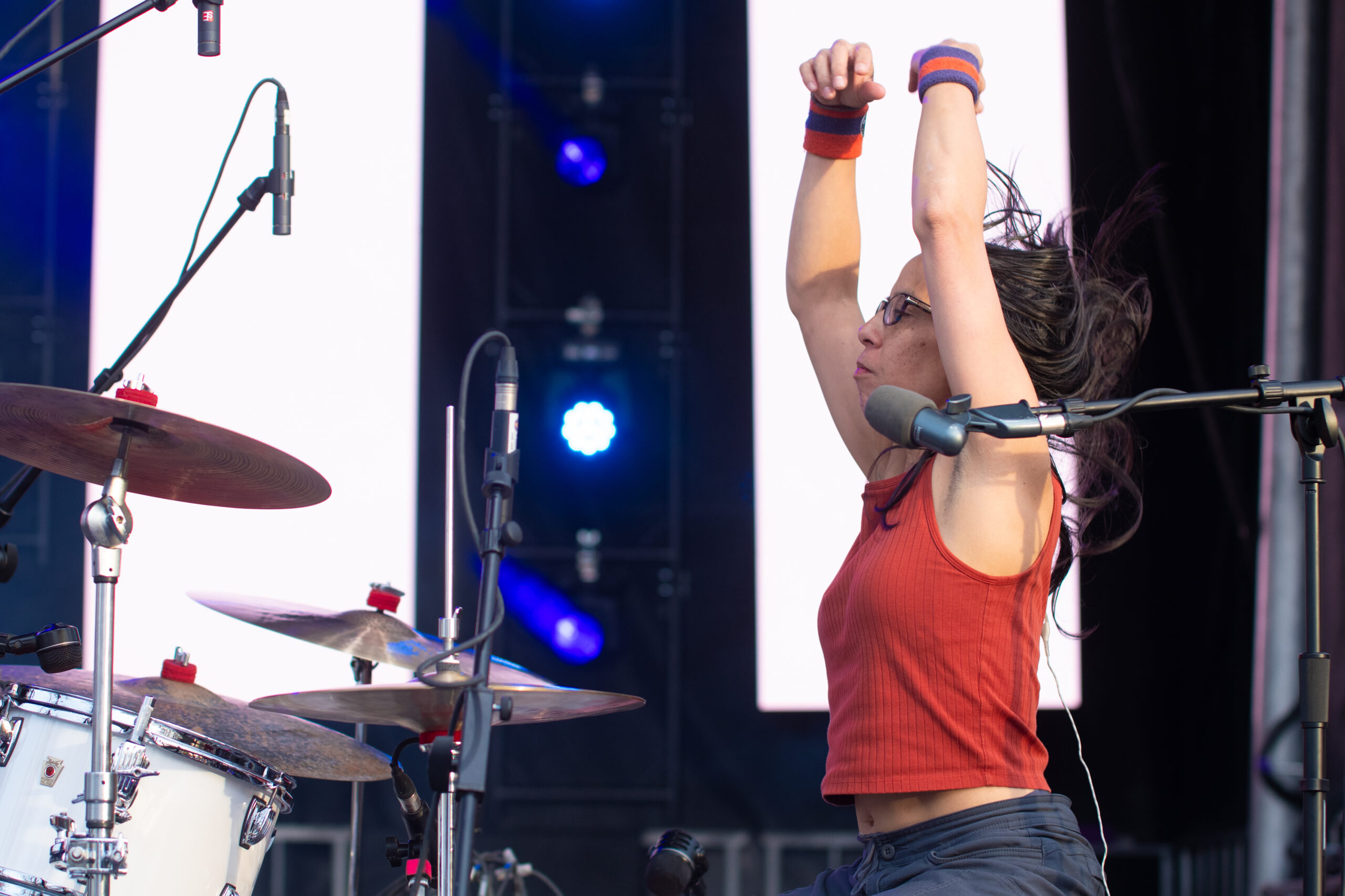 Teresa Esguerra drumming passionately during a live performance.