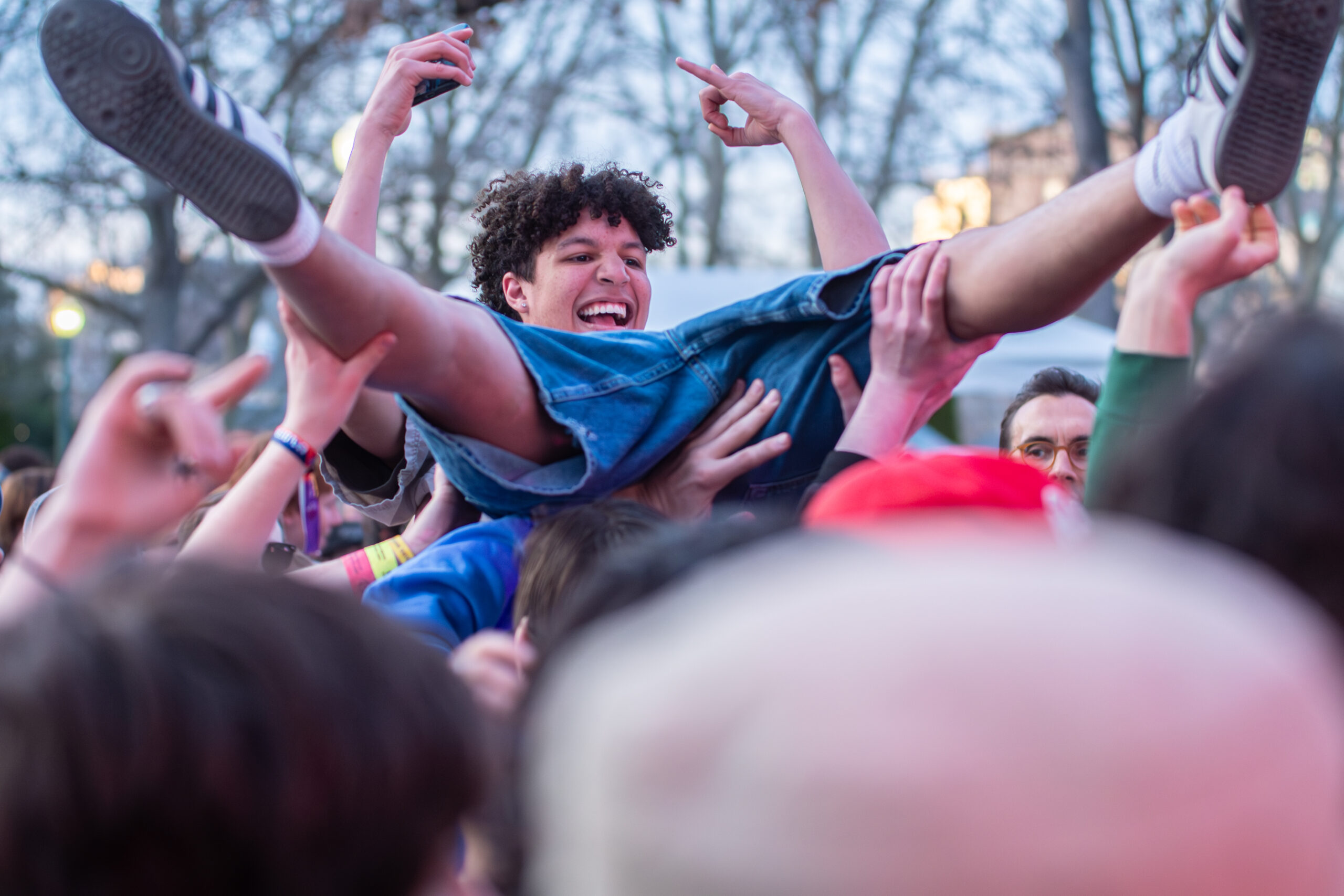 Close-up of a joyous fan being crowd-surfed at a concert.