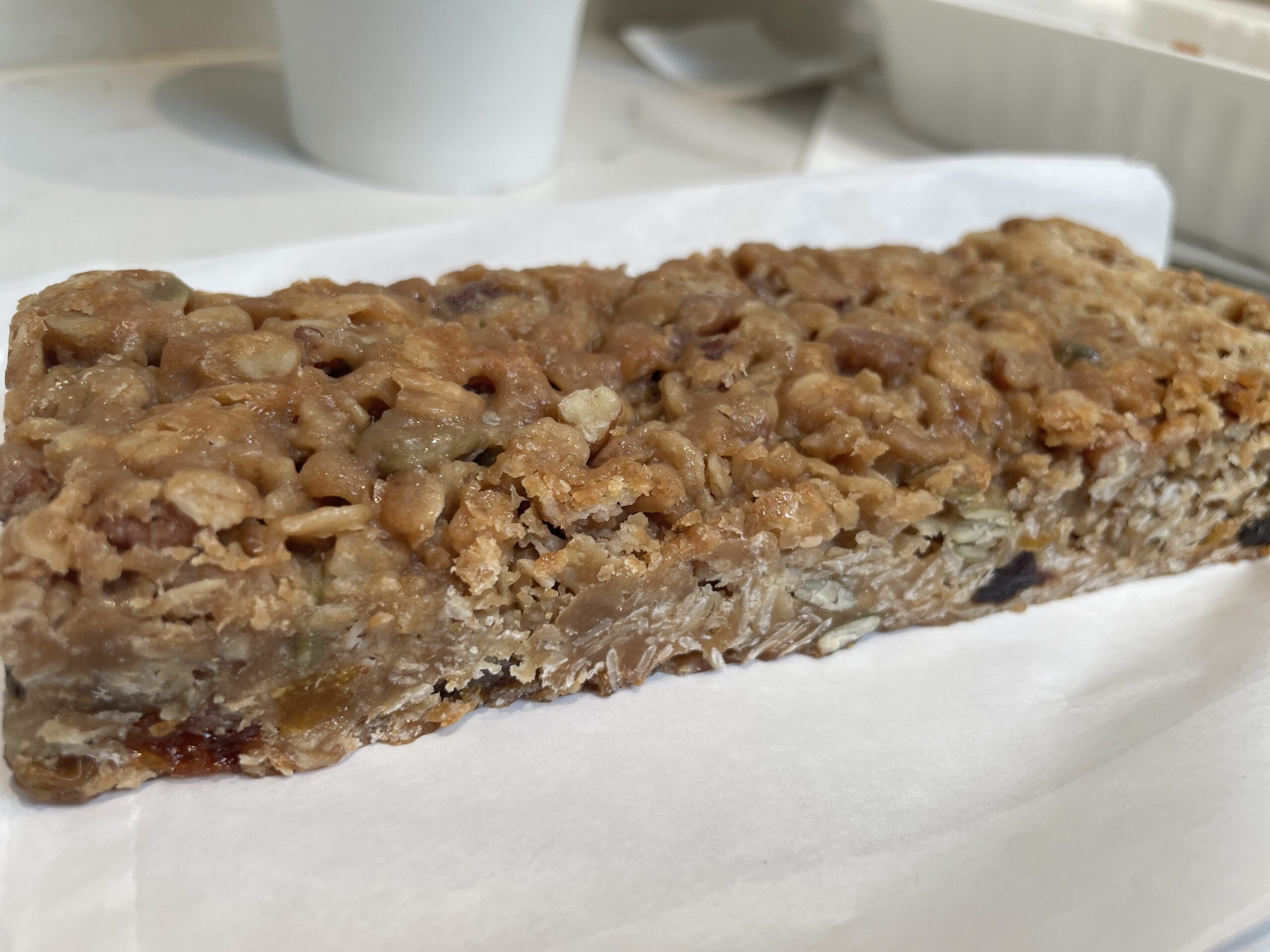 Delectable Blueberry Crumble Bar with a golden crumble topping and rich blueberry filling on a white plate at Certified Bakery.