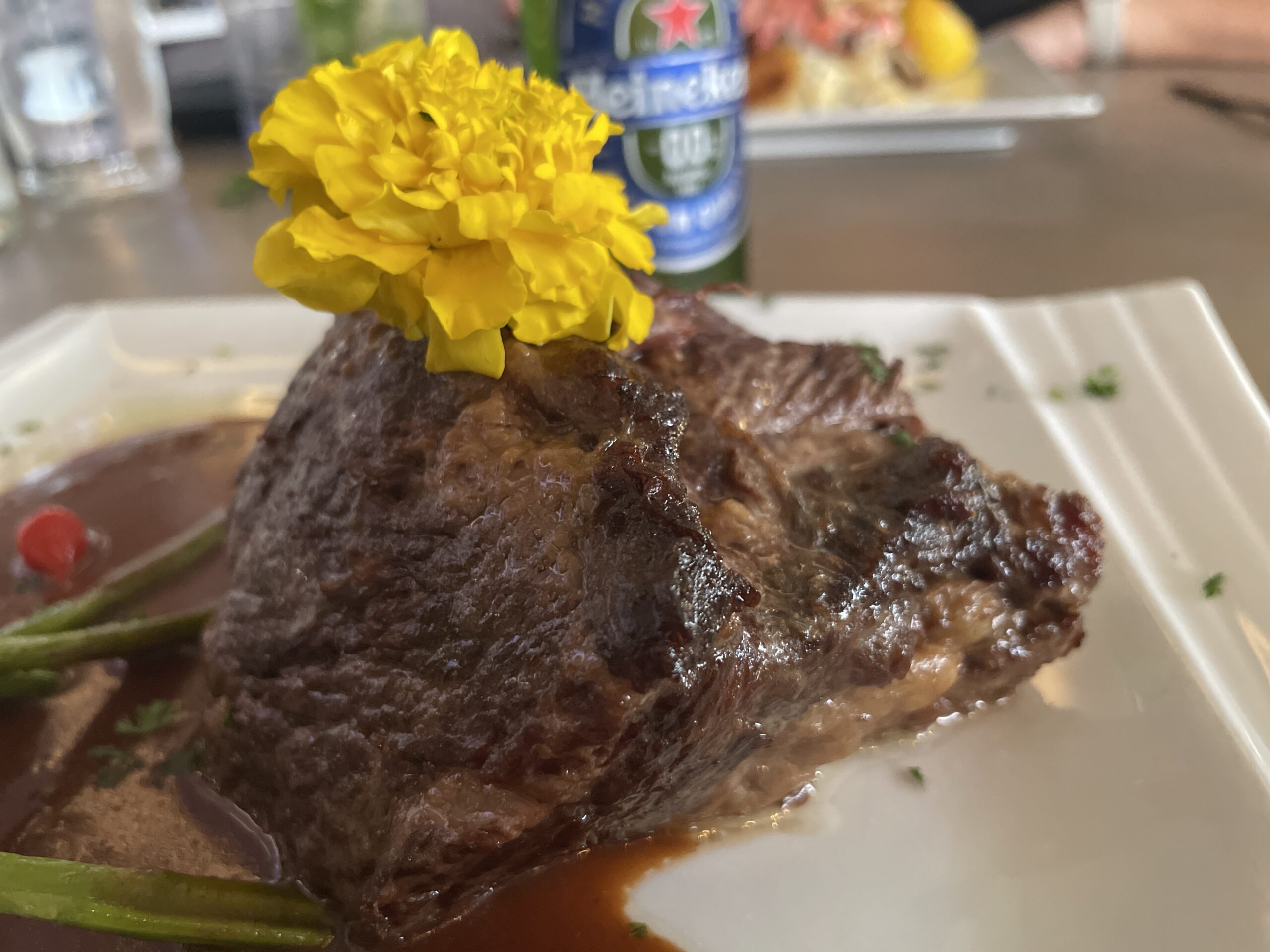 Coa Del Mar "Slow Braised Boneless short Ribs" with a flower on top.