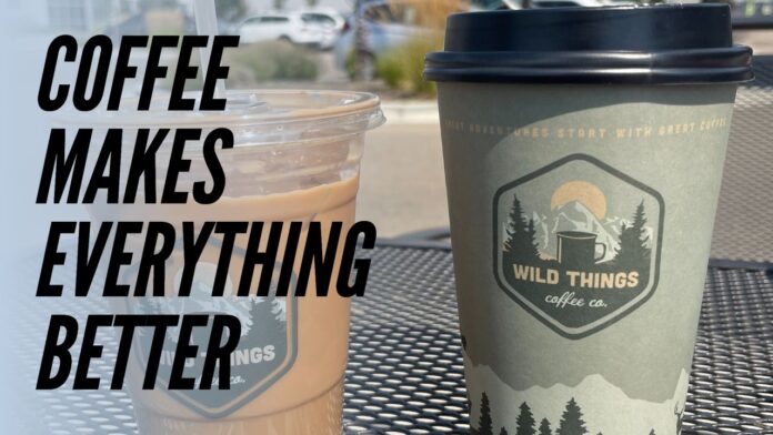 Two Wild Things Coffee cups, one iced and one hot, sitting on an outdoor table with the text 