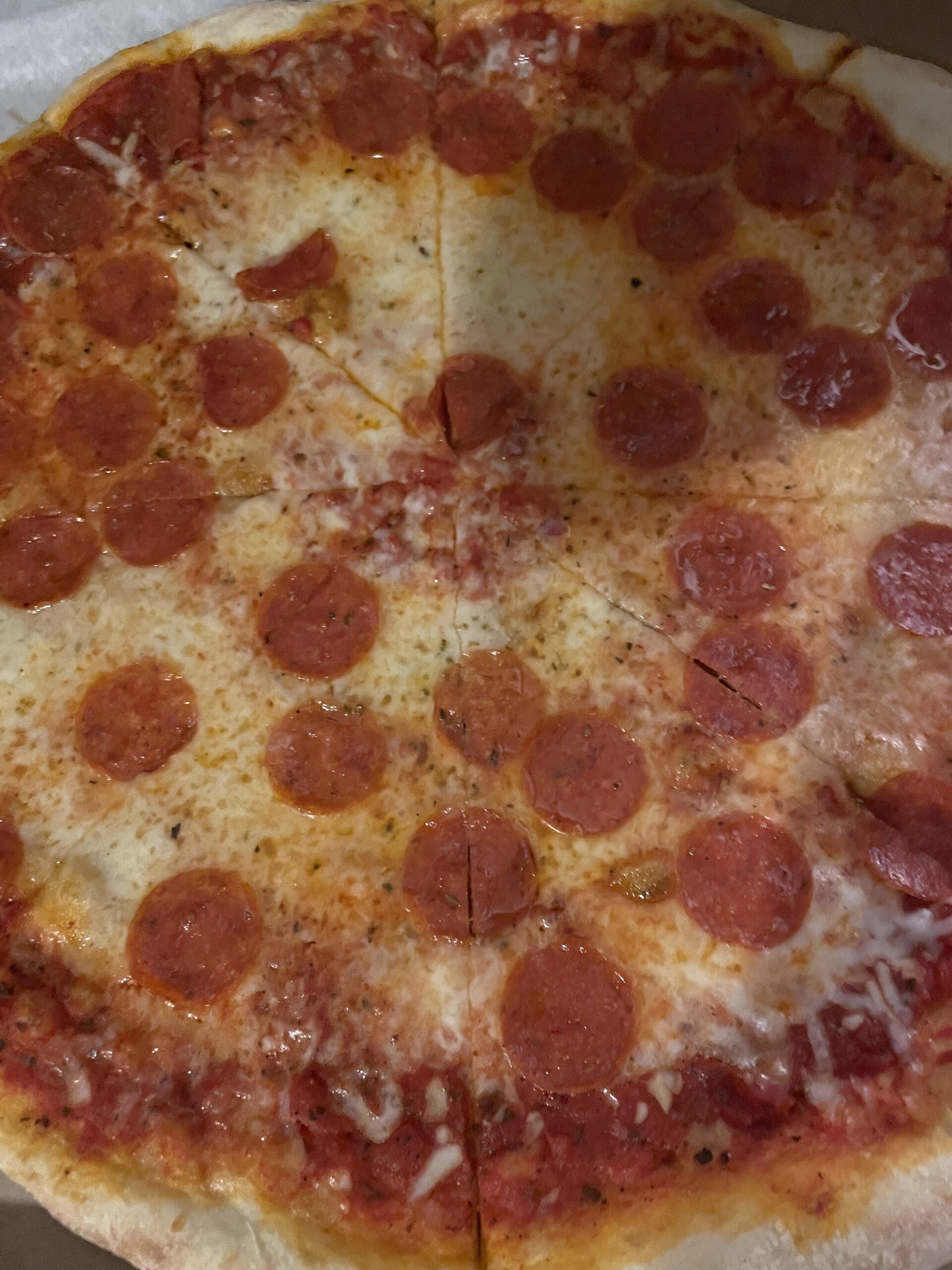 A freshly baked New York-style pepperoni pizza from Guido’s Original in Boise, Idaho, featuring a thin crust, tangy tomato sauce, melted mozzarella cheese, and perfectly crisped pepperoni slices.