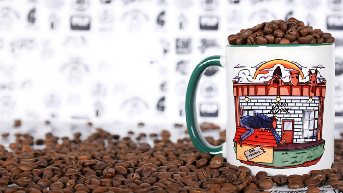 A colorful Push and Pour coffee mug filled with coffee beans, surrounded by scattered coffee beans.