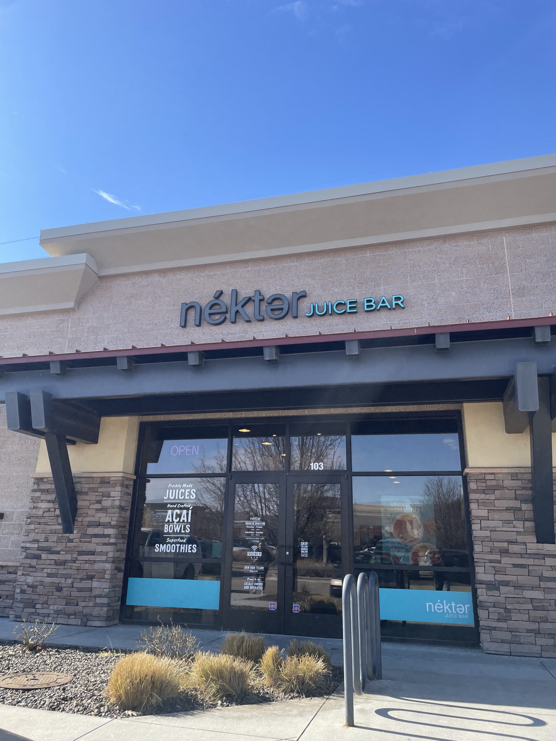 The exterior of Nekter Juice Bar in Meridian, Idaho, featuring signage advertising fresh juices, acai bowls, and smoothies.