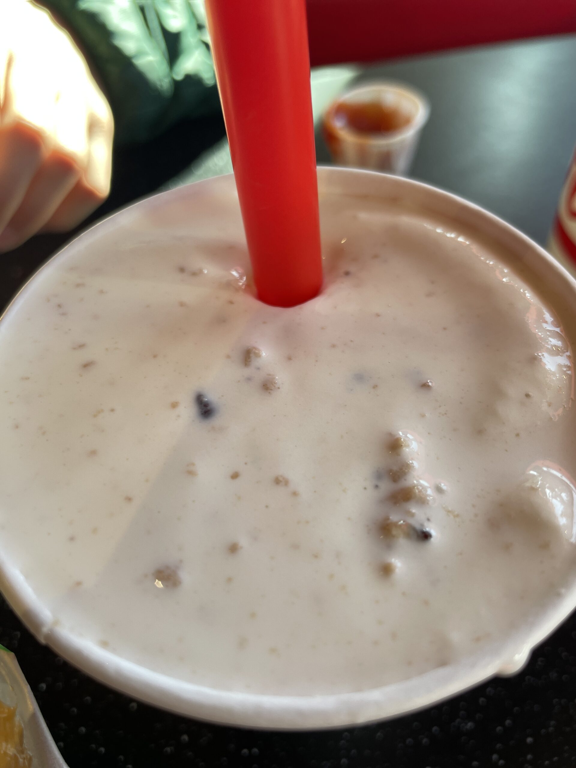 A creamy Freddy’s frozen custard shake with mix-ins and a red straw.