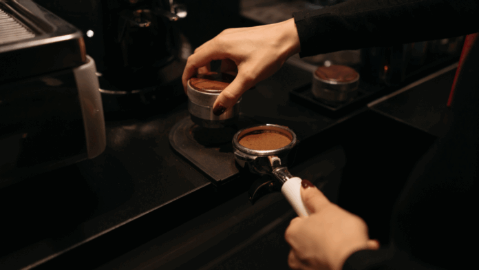 Barista tamping freshly ground espresso at Grindz Coffee in Garden City, Idaho.