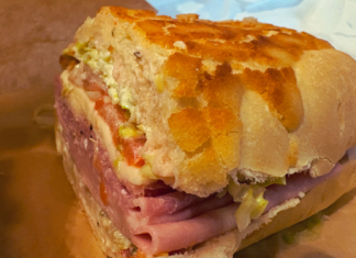 Close-up of Fratelli Deli’s Godfather sandwich on house-baked Dutch Crunch bread, layered with Italian meats, provolone, lettuce, tomato, and spicy giardiniera.