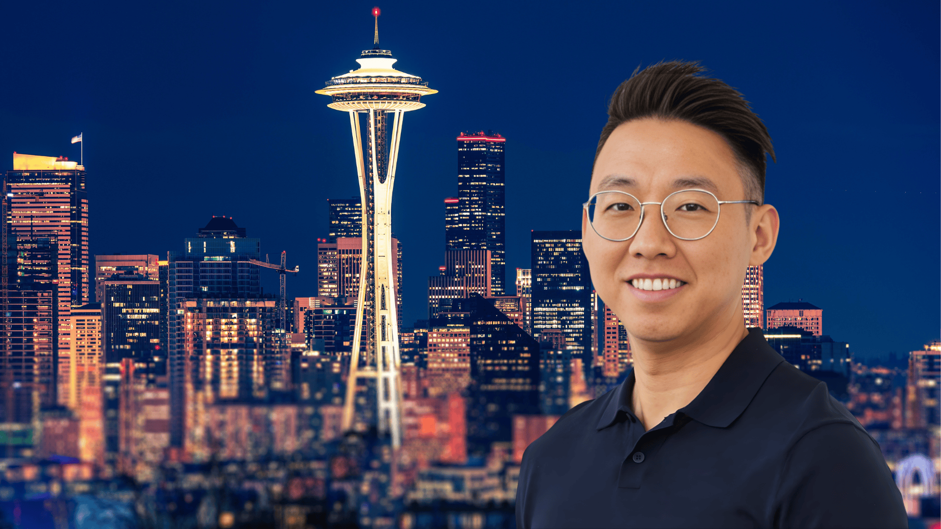 Dat Tran, stress resiliency coach and keynote speaker, smiling in front of the Seattle skyline with the Space Needle at night.