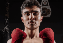 Elias Rivas on Boxing Nationals, Discipline, and Becoming More Than a Fighter Elias Rivas, an amateur boxer and USA Boxing prospect, poses with red hand wraps in a boxing gym ahead of his national boxing tournament appearance.