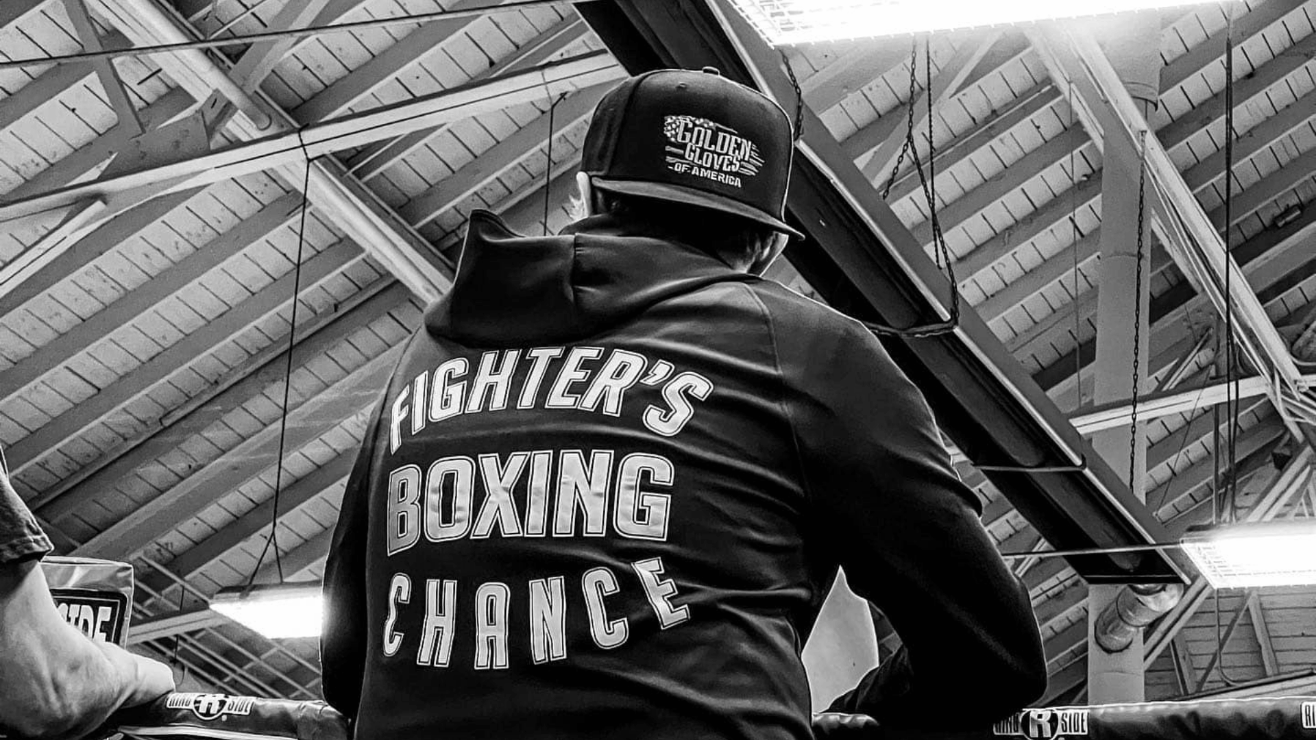Storm Pawson of Fighter’s Chance Boxing Gym sits ringside in a black-and-white image ahead of Fights on Fremont 5, a USA Boxing-sanctioned outdoor boxing event in Rupert, Idaho.